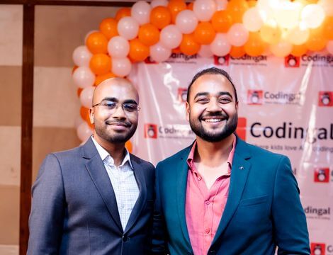 Orange balloons, a Codingal backdrop, and two proud grins at our 6th birthday 🎈 📸