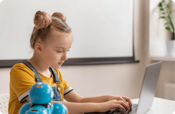 A child building and directing code at a laptop